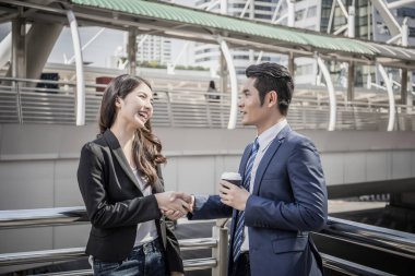 İş ortağı tabletteki başarılı işlere bakarken el sıkışıyor. İş konsepti.