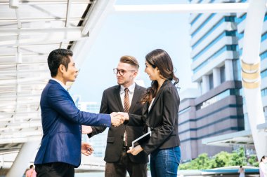 İş ortağı ofis önünde buluşurken el sıkışıyor ve gülümsüyor. İş ve başarı kavramı.