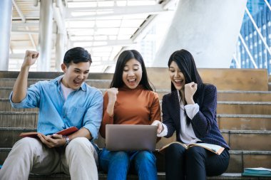 Grup öğrencileri laptopta araştırma yapıyor. Üniversitede birlikte oturuyorlar..