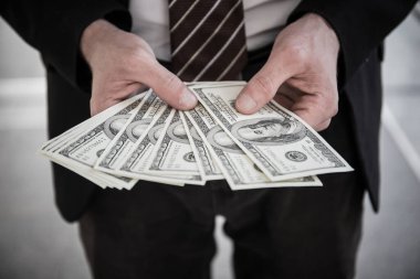 Dolarları tutan işadamının yakın plan fotoğrafı..