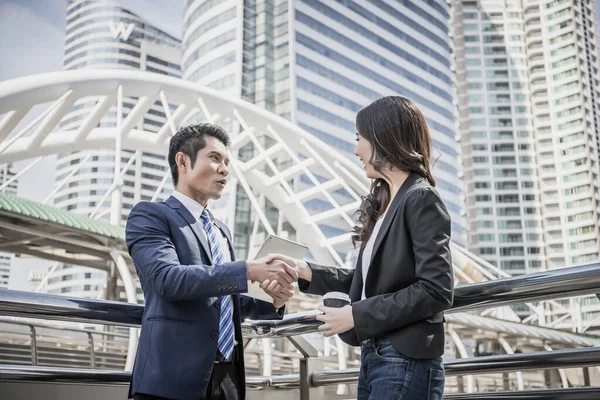 ビジネスパートナーは タブレットで成功した仕事を見ながら握手をします 事業概念 — ストック写真