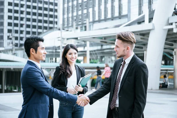 Business partner work hands shaking while looking at successful work at tablet. Business concept.