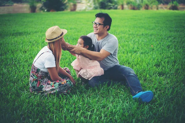 公園で幸せな若い家族の時間を過ごす お父さんの母親と娘は芝生の上で遊んで — ストック写真