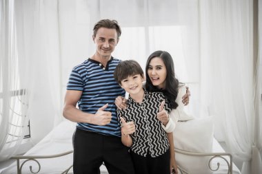 Anne, baba ve kız yatak odasında eğleniyorlar. Mutlu aile kavramı.