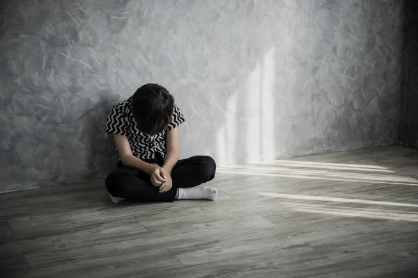 Smutny Chłopiec Siedzi Myśląc Siedząc Podłodze Pokoju Pod Ścianą Domu — Zdjęcie stockowe