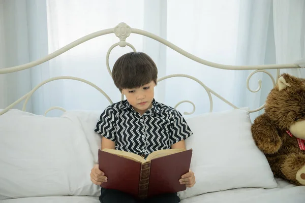 Young Boy Reading Book Bed Home — Stock Photo, Image