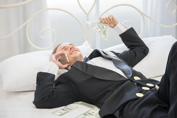 Dolar Banknotlarıyla Yatakta Yatan Zengin Bir Adam Başarı Konsepti — Stok fotoğraf