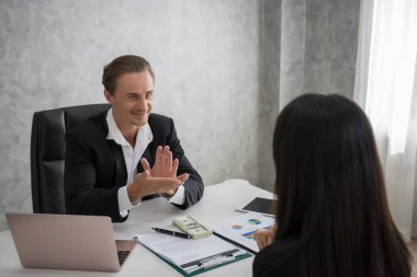 İş arkadaşları, başarı sözleşmesi kabul edildikten sonra birbirlerine gülümseyerek bakıyorlar..