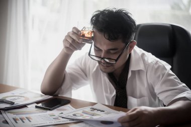 İş adamı iş yerinde stresten su içiyor