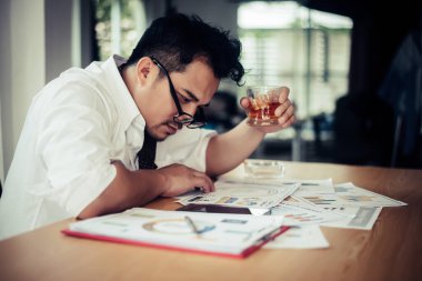 İş adamı iş yerinde stresten su içiyor