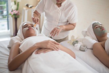 Spa maskesinin üzerine uzanmış güzel bir kadın. Spa tedavisi görüyor, rahat ve sağlıklı.