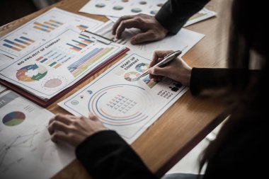 Girişimci iş adamları grup toplantısı. İnsanlar konferansta birlikte oturup notlar alıyorlar. Toplantıda iş belgesine işaret eden eller.