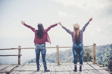 Kadın dışarıda rahatlıyor. Mutlu görünüyor ve gülümsüyor.