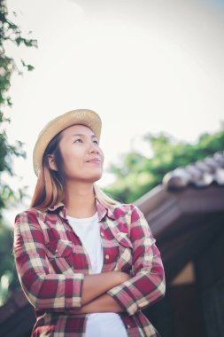 Kadın dışarıda rahatlıyor. Mutlu görünüyor ve gülümsüyor.