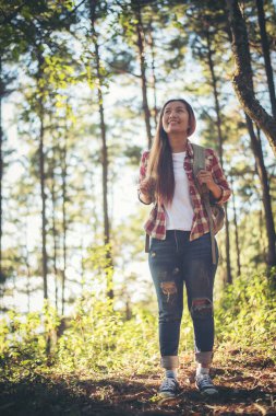 Genç bir kadın ormanda yürüyor. 