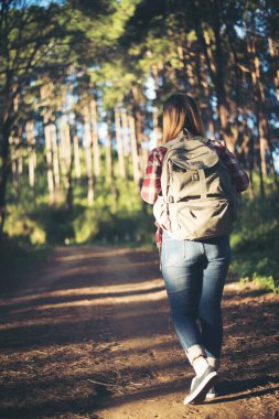 Genç bir kadın ormanda yürüyor. 