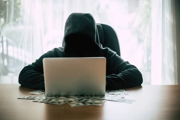 黑客在他的计算机前面用美元钞票 — 图库照片
