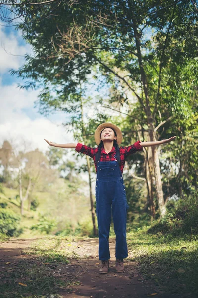 Genç bir kadın ormanda yürüyor. 