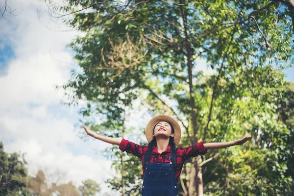 Kadın dışarıda rahatlıyor. Mutlu görünüyor ve gülümsüyor.