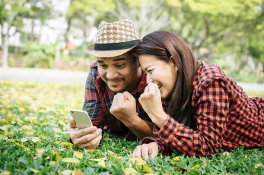 Romantik bir çift genç parkta çimlerin üzerinde yatıyor..