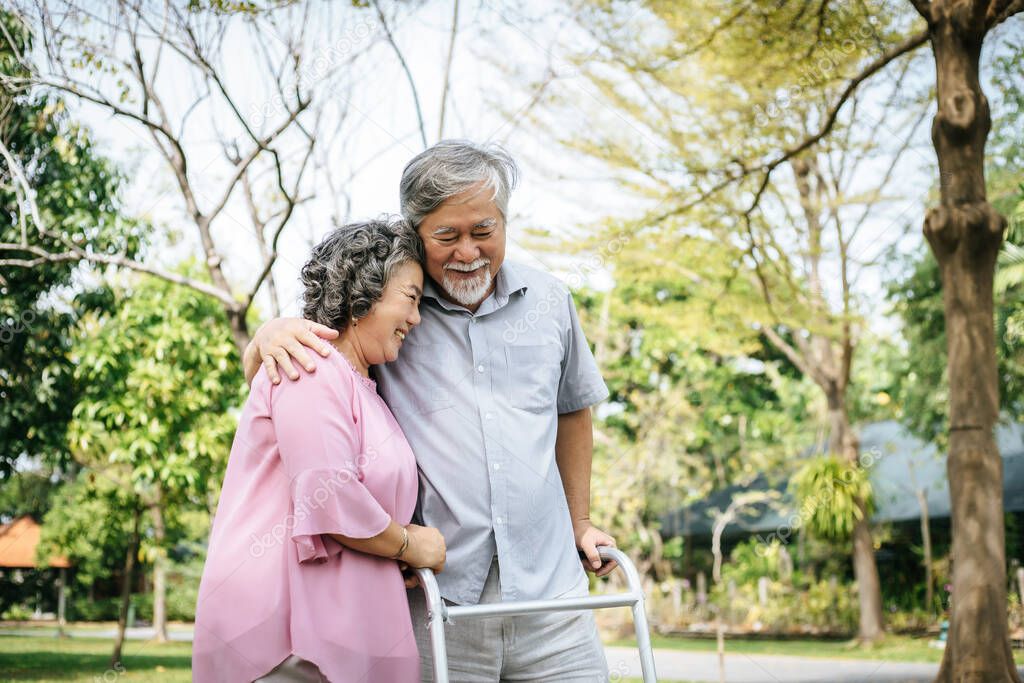 assisting her senior patient who's using a walker for support