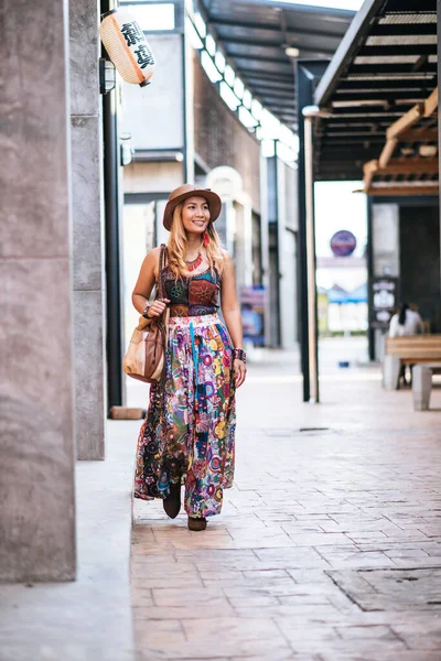 The woman is walking on the street with great smile.