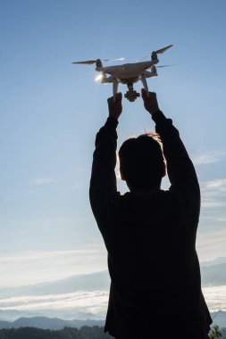 Erkeklerin elleri dronu tutar, alır.