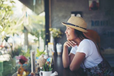 Pencerenin yanındaki kafede güzel bir kız. Kahvesi gülümsüyor.