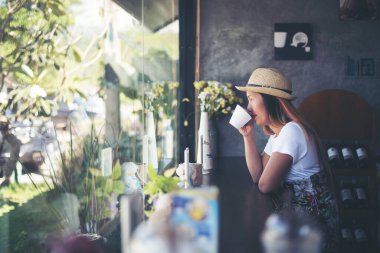 Pencerenin yanındaki kafede güzel bir kız. Kahvesi gülümsüyor.