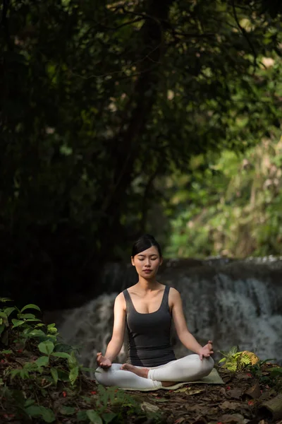 Ung Kvinna Yogaposer Som Sitter Nära Vattenfallet — Stockfoto