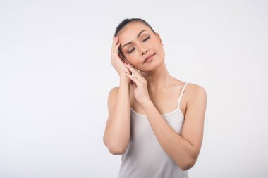 Temiz tenli güzel genç bir kadın, kendi yüzüne dokunur. 