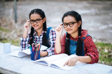 Parkta dizüstü bilgisayarla birlikte çalışan iki öğrenci.