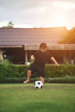 Küçük çocuk futbol oynuyor.