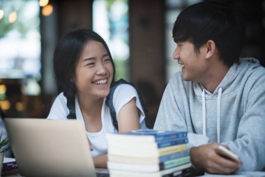 Bir grup mutlu öğrenci kafede bilgiden bahsediyor.