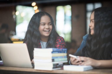 Bir grup mutlu öğrenci kafede bilgiden bahsediyor.