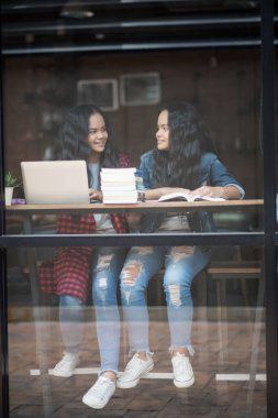 Bir grup mutlu öğrenci kafede bilgiden bahsediyor.