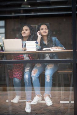Bir grup mutlu öğrenci kafede bilgiden bahsediyor.