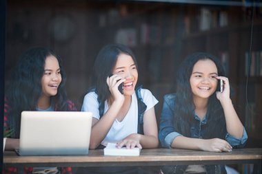 Bir grup mutlu öğrenci kafede bilgiden bahsediyor.