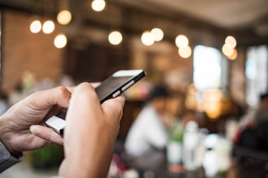 Genç bir kadın mutlu bir şekilde akıllı telefon kullanıyor ve bakıyor.