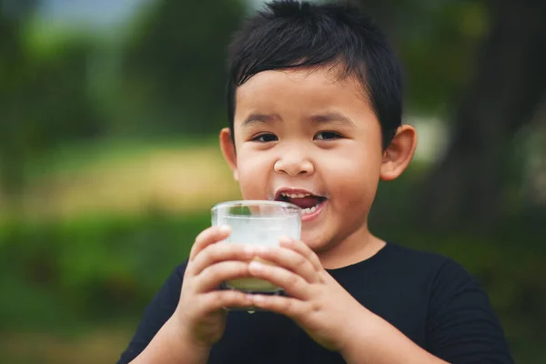 小男孩在公园里喝牛奶 — 图库照片