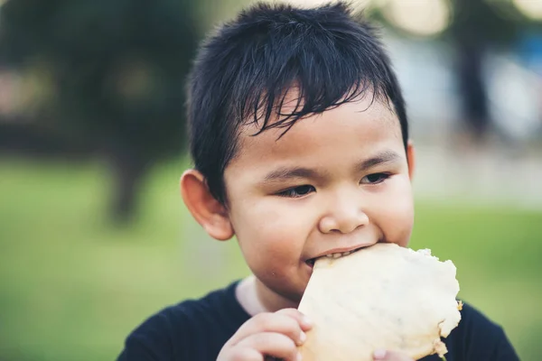 小男孩正在吃新鲜的面包卷三明治 — 图库照片