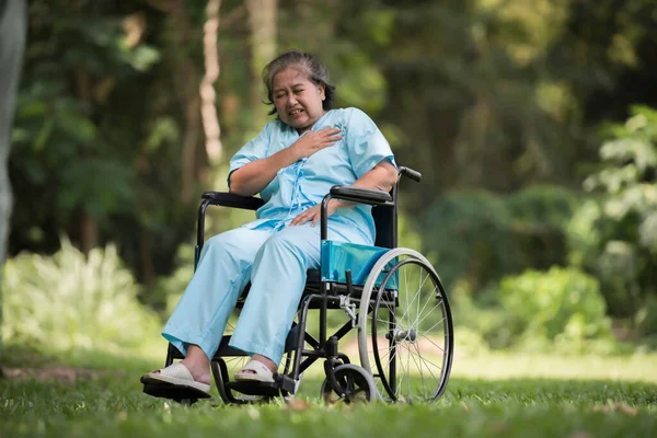 病院の庭で車椅子に悲しい気持ちで座っている孤独な高齢女性 — ストック写真