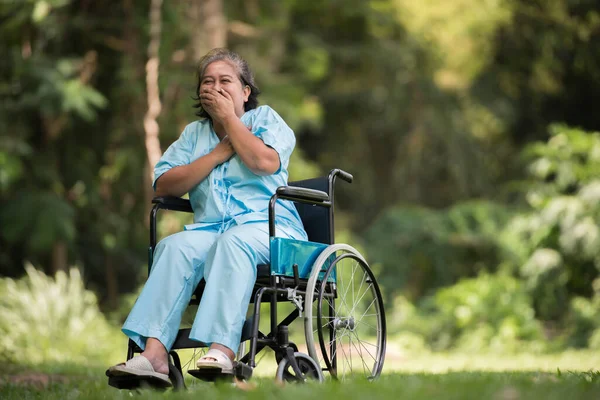 病院の庭で車椅子に悲しい気持ちで座っている孤独な高齢女性 — ストック写真