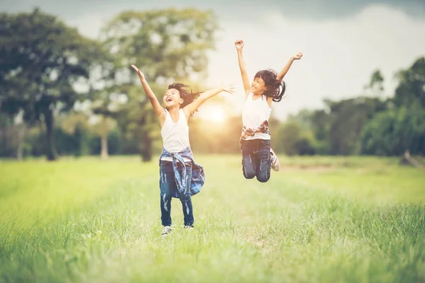 Two Little Girls Happy Jump Nature Park — Stock Photo, Image