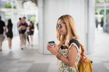 Şehir gezisinde kahve içen mutlu genç şehir kadını