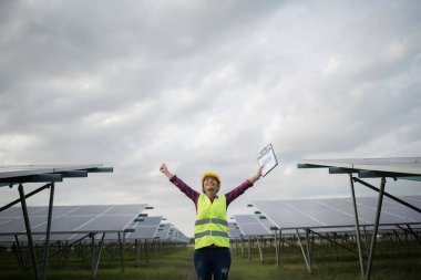 Elektrik mühendisi kadın güneş pillerini kontrol ediyor..