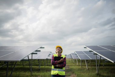 Elektrik mühendisi kadın güneş pillerini kontrol ediyor..