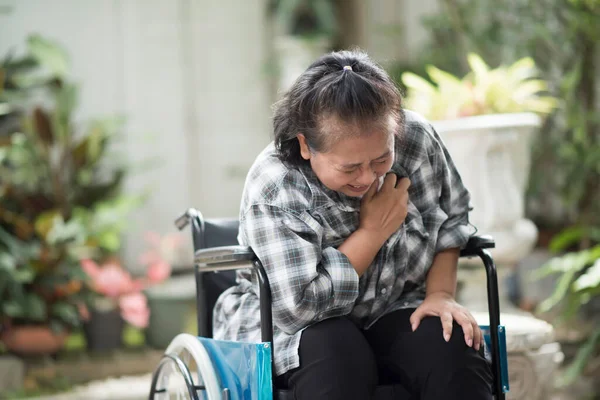 高齢女性は車椅子に座って心臓病にかかり — ストック写真