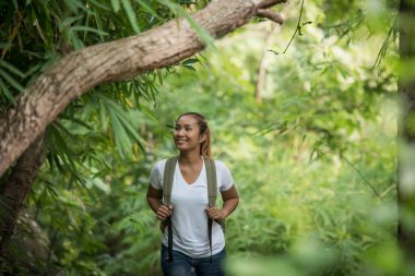 Ormanda doğa ile mutlu bir şekilde yürüyen genç bir sırt çantasına. Seyahat kavramı.