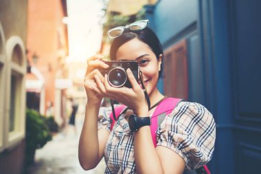 Genç hippi kadın sırt çantasıyla şehir merkezinde fotoğraf çektirirken..